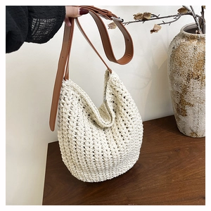 Detailed texture of hand-woven beige tote bag with premium brown leather strap