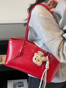 Red large capacity faux leather tote bag with teddy bear pendant and tassel detail