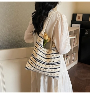 Detail of hand-crocheted cream tote bag with black stripes and hollow knit pattern