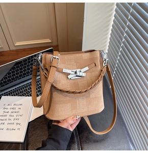 Close-up of beige bucket bag with checkerboard texture, silver buckle, and woven handle