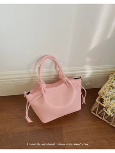 Detail of pink PU leather handbag showing unique drawstring knot and smooth texture