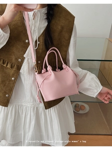 Detail of pink vintage bucket bag with knotted handle and adjustable strap on model