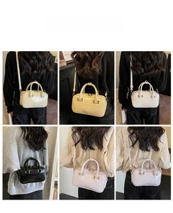 Detail showing various colors of the shiny leather Boston handbag with gold hardware