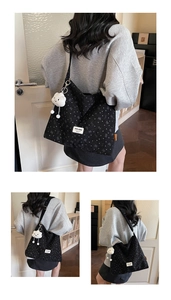 Detail of black canvas tote bag with heart pattern and cute white cloud plush pendant