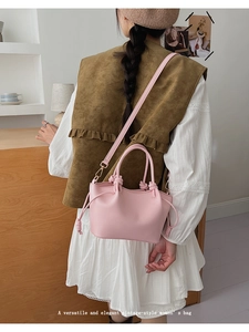 Detail of pink vintage shoulder bag with woven knot design on a model back view