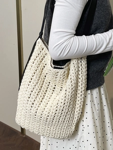 Minimalist woven straw tote bag with black leather straps for elegant daily commute