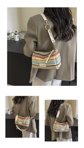 Detail of colorful striped woven cylinder bag with white leather strap and gold hardware