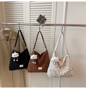Three large tote bags in black, brown, and beige with bow prints and plush charms