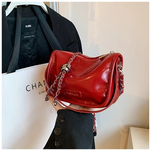 Detail of red patent leather mini bag with silver zipper and silver chain strap