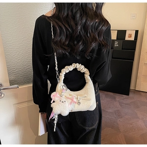 Détail du sac hobo plissé blanc crème avec nœud et adorable breloque lapin en peluche