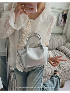 Detail showing the silver metallic ring handle and side knot design on this elegant bag