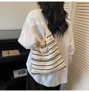 Detail view of cream and navy striped crochet bucket bag with hollow woven texture