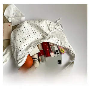 Spacious interior of white polka dot canvas crossbody bag showing large capacity with daily items