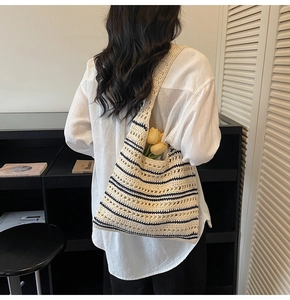 Detail of crochet straw tote bag with navy blue stripes and hollow mesh pattern