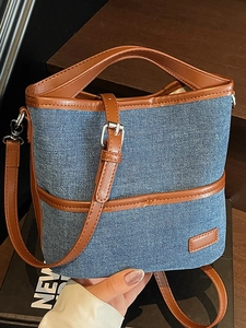 Blaue Denim-Beuteltasche mit braunem Lederbesatz und Schultergurt im Casual-Stil