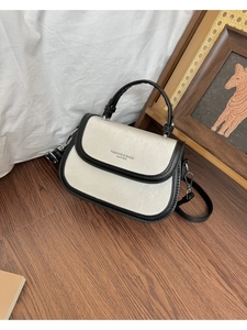 Vue détaillée du sac selle bicolore noir et blanc élégant avec texture cuir et sangle