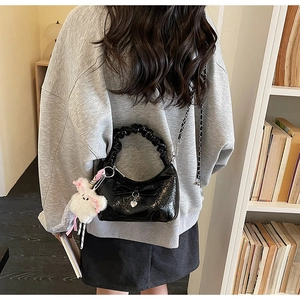 Détail du sac nuage noir plissé avec nœud, breloque cœur et peluche de lapin