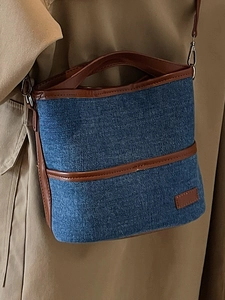 Minimalistische Denim-Eimertasche mit braunem Lederbesatz und abnehmbarem Schultergurt