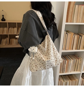 Detail of beige corduroy tote bag with brown pattern and cute cloud charm pendant