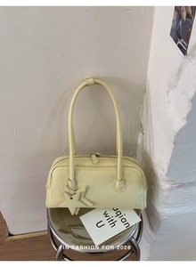 Détail du sac bowling en cuir jaune crème avec pendentifs étoiles et fermeture éclair