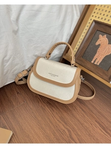 Détail du sac à bandoulière en cuir bicolore beige et kaki avec boucle argentée et texte