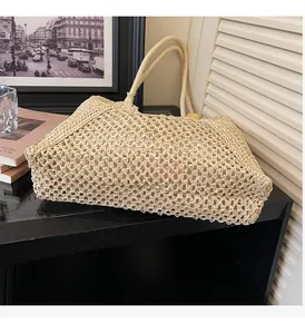 Close-up of beige woven tote bag with intricate mesh pattern and sturdy handles