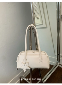 Détail du sac baguette en cuir crème avec pendentif étoile et fines bandoulières