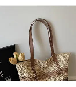 Détail du sac cabas tissé avec bandoulières en cuir marron et fermeture éclair dorée