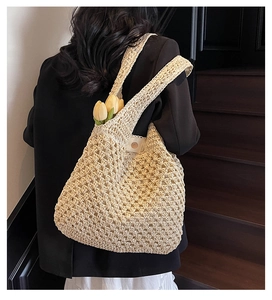 Detailed view of beige crochet tote bag with mesh woven texture on model's shoulder