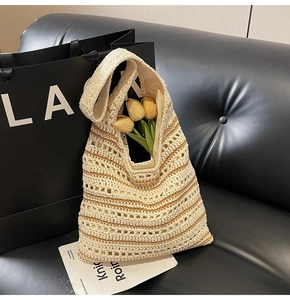 Close-up of handmade crochet straw tote bag with hollow knit texture and floral decoration