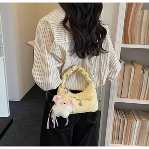 Détail du sac nuage jaune clair avec nœud, breloque cœur et pendentif ours en peluche
