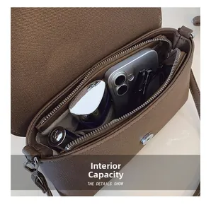 Detail view of the brown shoulder bag showing internal capacity and zipper pocket
