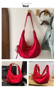 Detail of red and white polka dot canvas croissant bag with side drawstring bow knots