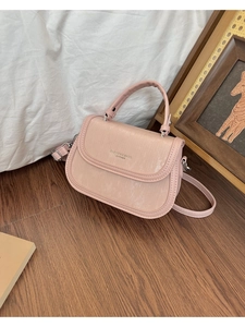 Détail du sac bandoulière en cuir gaufré rose avec ferrures argentées et poignée fixe