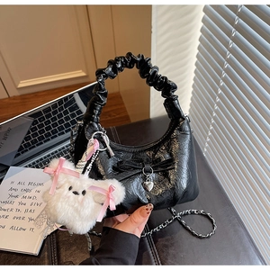 Détail du sac croissant plissé noir avec breloque cœur et accessoire lapin peluche