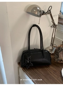 Sac baguette noir élégant avec surpiqûres blanches et pendentif en forme d'étoile