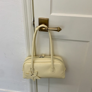 Détail du sac à bandoulière Boston jaune crème avec charm étoile et zip argenté