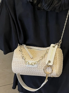 Beige woven straw pillow bag with white leather straps and gold floral chain detail