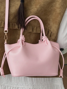 Pink PU leather bucket tote bag with unique knotted handles and decorative side tassels