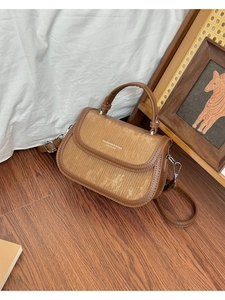 Détail de la texture du sac en velours côtelé marron et bandoulière sur le sol