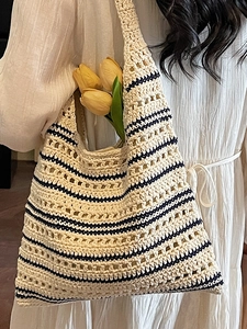 Chic woven straw bucket bag with navy stripes and hollow mesh design for summer vacation