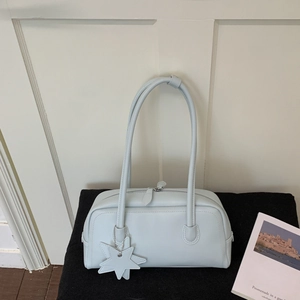Détail du sac baguette bleu clair avec charm étoile et bandoulières en cuir fin