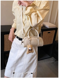 Ivory Boston bag with wrinkled patent texture and cute brown teddy bear keychain detail