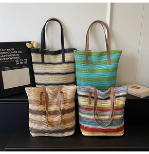 Detail view of four colorful woven straw tote bags with faux leather handles for beach vacation