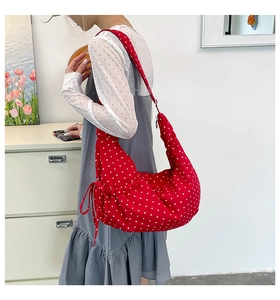 Detail of red polka dot canvas shoulder bag with unique side drawstring pleats