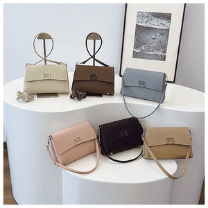 Selection of colorful minimalist flap shoulder bags with metallic M logo on white display