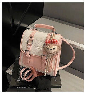 Detail of pink and white textured leather mini bag with a cute plush bear charm