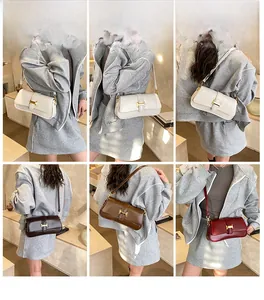Detail view of stylish underarm bags in white brown and red with H-shaped metal buckles