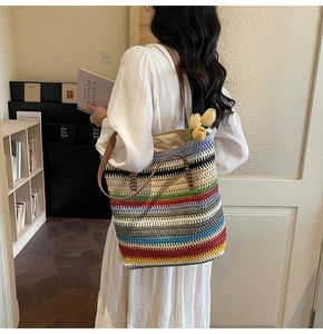 Détail du sac fourre-tout tissé à rayures colorées porté par un mannequin en robe