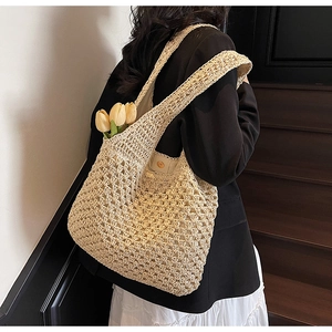 Detail of handwoven straw tote bag with intricate crochet patterns and a large capacity